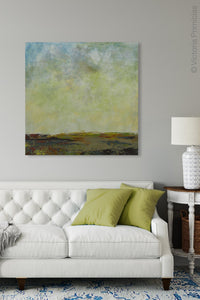Square abstract landscape art "Canary Winds," digital print by Victoria Primicias, decorates the living room.