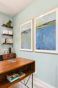 Blue abstract coastal wall art "Daily Caller," metal print by Victoria Primicias, decorates the office.