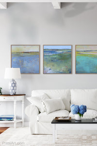 Blue abstract coastal wall art "Daily Caller," metal print by Victoria Primicias, decorates the living room.