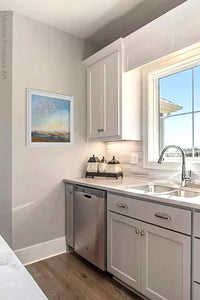 Square abstract landscape art "Faraway Nearby," giclee print by Victoria Primicias, decorates the kitchen.
