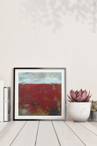 Square red abstract beach wall decor "Ferrari Run," digital print by Victoria Primicias, decorates the shelf.