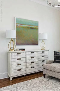 Coastal abstract landscape painting "Fine Margin," digital download by Victoria Primicias, decorates the living room.