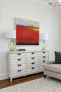 Large red abstract coastal wall art "Fire Sea," fine art print by Victoria Primicias, decorates the living room.