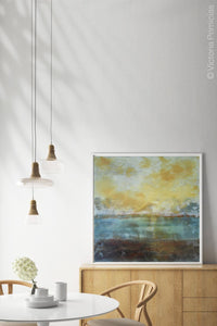 Yellow and teal abstract coastal wall decor "Guardian Light," metal print by Victoria Primicias, decorates the dining room.