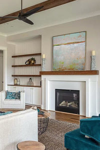 Gray abstract ocean painting "Ivory Shore," fine art print by Victoria Primicias, decorates the fireplace.