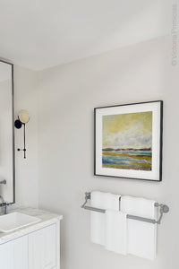 Yellow coastal abstract landscape art "Lapping Layers," canvas print by Victoria Primicias, decorates the bathroom.
