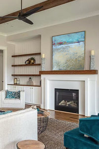 Tan abstract ocean painting "Mint Melody," printable wall art by Victoria Primicias, decorates the fireplace.