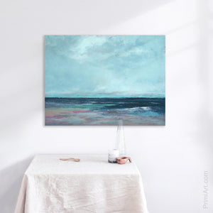 abstract coastal painting hangs above a table