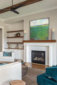 Green abstract landscape art "On Course," digital print by Victoria Primicias, decorates the fireplace.