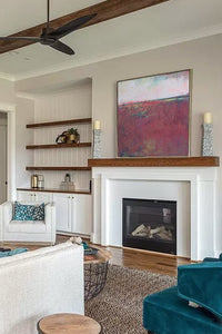 Burgundy abstract beach wall art "Red Tide," downloadable art by Victoria Primicias, decorates the fireplace.