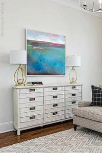 Teal coastal abstract beach wall decor "Rising Tides," downloadable art by Victoria Primicias, decorates the living room.