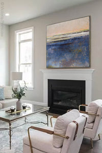 Indigo blue abstract landscape painting "Secret Waters," wall art print by Victoria Primicias, decorates the fireplace.