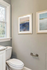 Indigo blue abstract coastal wall art "Secret Waters," canvas art print by Victoria Primicias, decorates the bathroom.