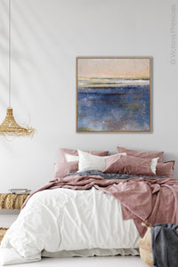 Indigo blue abstract coastal wall art "Secret Waters," canvas art print by Victoria Primicias, decorates the bedroom.