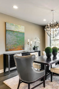 Horizon landscape painting "Shamrock Shoals," digital download by Victoria Primicias, decorates the dining room.