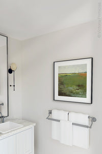 Green abstract landscape art "Spring Envy," wall art print by Victoria Primicias, decorates the bathroom.
