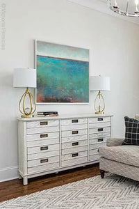 Turquoise abstract coastal wall art "Tides End," metal print by Victoria Primicias, decorates the living room.
